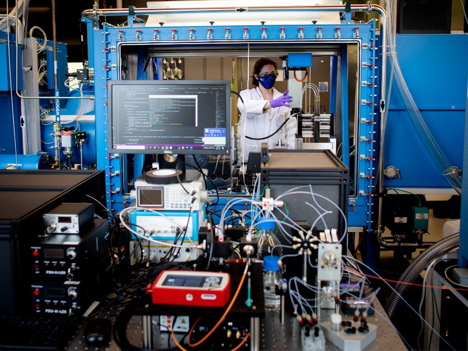 Female scientist conducts experiments inside a laboratory with electrical equipment